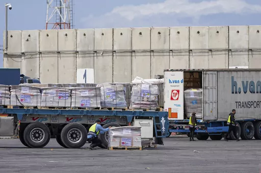 Trucks carrying humanitarian aid for the Gaza Strip pass through the inspection area at the Kerem Shalom Crossing in southern Israel, Thursday, March 14, 2024. (AP Photo/Ohad Zwigenberg)