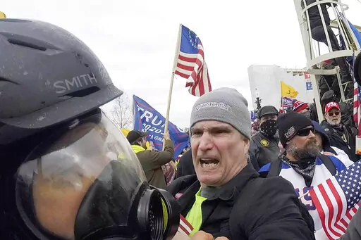In this image from video, Alan William Byerly, center, attacks an Associated Press photographer during a riot at the U.S. Capitol in Washington, Jan. 6, 2021. On Sunday, Oct. 9, 2022, federal prosecutors recommended a prison sentence of nearly four years for Byerly, of Pennsylvania, who pleaded guilty to assaulting the AP photographer and using a stun gun against police officers during a mob's attack on the U.S. Capitol. (AP Photo/Julio Cortez, File)