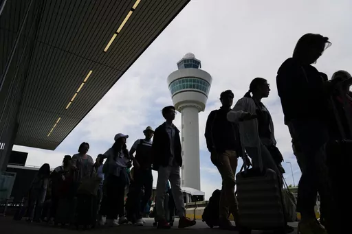 Travelers wait in long lines outside the terminal building to check in and board flights at Amsterdam's Schiphol Airport, Netherlands, on June 21, 2022. A judge ruled Wednesday April 5, 2023 that the Dutch government cannot order Amsterdam's Schiphol Airport, one of Europe's busiest aviation hubs, to reduce the number of flights from 500,000 per year to 460,000, dealing a blow to efforts to cut emissions and noise pollution.(AP Photo/Peter Dejong, File)