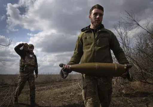 Ukrainian soldiers carry shells to fire at Russian positions on the front line, near the city of Bakhmut, in Ukraine's Donetsk region, on March 25, 2024. (AP Photo/Efrem Lukatsky, File)