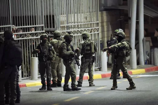 Israeli security forces patrol next to the scene of a shooting attack near the Shuafat refugee camp in Jerusalem, Saturday, Oct. 8, 2022. Israeli police say armed assailants have opened fire at an Israeli military checkpoint in east Jerusalem, seriously wounding at least two people. (AP Photo/Mahmoud Illean)