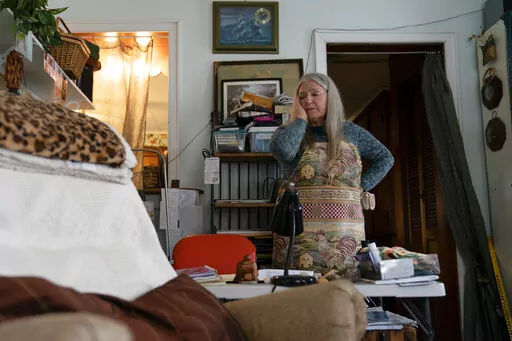 Nancy Rose, who contracted COVID-19 in 2021 and continues to exhibit long-haul symptoms including brain fog and memory difficulties, pauses while organizing her desk space, Tuesday, Jan. 25, 2022, in Port Jefferson, N.Y. Rose, 67, said many of her symptoms waned after she got vaccinated, though she still has bouts of fatigue and memory loss. A report from the Centers for Disease Control and Prevention released on Wednesday, May 25, 2022, found that up to a year after an initial coronavirus infec