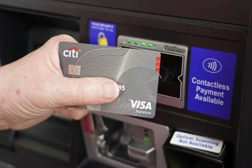 A customer uses the contactless payment chip in their Visa card to purchase gasoline at a station in Ridgeland, Miss., Thursday, July 1, 2021.   Americans who for years have enjoyed the benefits of historically low interest rates will have to adapt to a very different environment as the Federal Reserve embarks on what's expected to be a prolonged period of rate hikes to fight inflation. (AP Photo/Rogelio V. Solis, File)