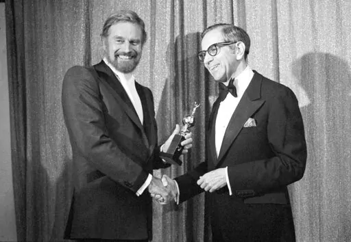 Walter Mirisch, right, and Charlton Heston celebrate at the 34th annual Golden Globe awards, presented by the Hollywood Foreign Press Association at the Beverly Hilton in Los Angeles, on Jan. 29, 1977. Mirisch, the astute and Oscar winning film producer who oversaw such classics as “Some Like It Hot,” “West Side Story” and “In the Heat of the Night,” has died of natural causes, the Academy of Motion Picture Arts and Sciences said Saturday, Feb. 25, 2023. He was 101. (AP Photo, File)