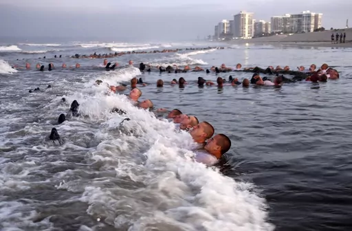 U.S. Navy SEAL candidates, participate in "surf immersion" during Basic Underwater Demolition/SEAL (BUD/S) training at the Naval Special Warfare (NSW) Center in Coronado, Calif., on May 4, 2020. The training program for Navy SEALs is plagued by widespread medical failures, poor oversight and the use of performance enhancing drugs that have increased the risk of injury and death to candidates seeking to become an elite commando, according to a highly critical new investigation triggered by the de
