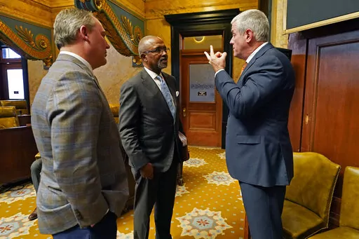 Rep. Robert Johnson, D-Natchez, center, confers with House Speaker Philip Gunn, R-Clinton, right, and House Speaker Pro Tempore Jason White, R-West, during a break, in chamber, Monday, March 28, 2022, at the Mississippi Capitol in Jackson. (AP Photo/Rogelio V. Solis)