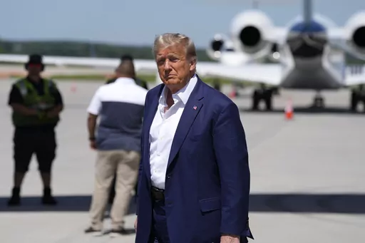 Republican presidential candidate former President Donald Trump walks to his vehicle after arriving at the Des Moines International Airport before his visit to the Iowa State Fair, Saturday, Aug. 12, 2023, in Des Moines, Iowa. (AP Photo/Charlie Neibergall)