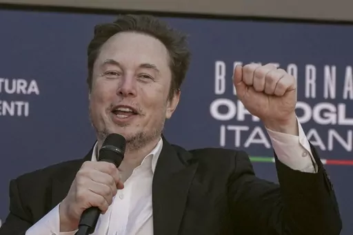 Tesla CEO Elon Musk waves as he arrives at the annual political festival Atreju, organized by the Giorgia Meloni's Brothers of Italy political party, in Rome, Dec. 16, 2023. A judge says Elon Musk must give up a compensation package awarded by Tesla's board of directors that is potentially worth more than $55 billion. (AP Photo/Alessandra Tarantino, File)