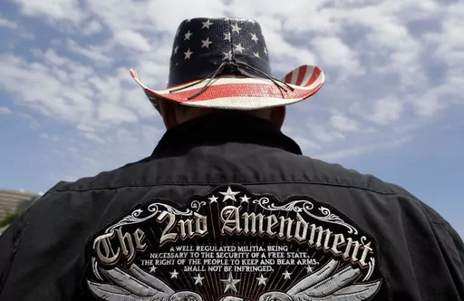 A man wears a patriotic-themed cowboy hat during a pro gun-rights rally at the Texas Capitol, April 14, 2018, in Austin, Texas. Guns have long been a part of Texas culture — both in the state’s mythology and in reality. But to equate the number of guns with the number of people killed by guns strikes some as a false equivalence. (AP Photo/Eric Gay, File)