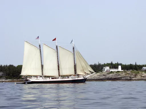 The Schooner Victory Chimes sails past the Pemaquid Point Light in Bristol, Maine, June 24, 2003. The 123-year-old schooner that was once declared the “Official Windjammer of Maine” by state lawmakers has new owners, and will be leaving Maine. (AP Photo/Annie Higbee, File)