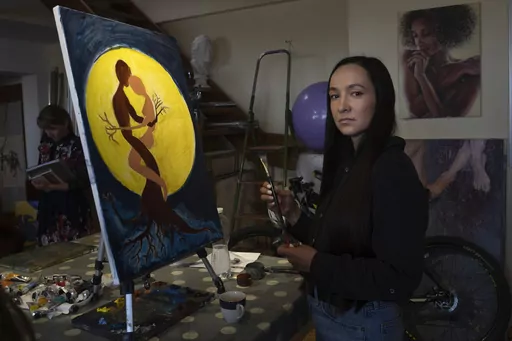 Iryna Farion, whose husband Oleksandr Alimov, a soldier, was killed in a battle with tRussian troops, paints a picture in an art studio in Kyiv, Ukraine, Saturday, June 3, 2023. For some Ukrainian women, painting has become a form of therapy to help them cope with the loss of their partners who died in the war. In a sunlit art studio in Kyiv, they create artworks depicting their grief. (AP Photo/Efrem Lukatsky)