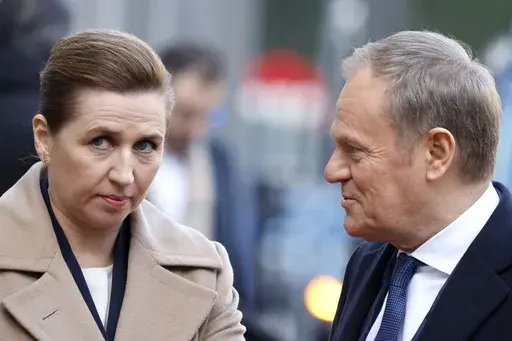 Denmark's Prime Minister Mette Frederiksen, left, speaks with Poland's Prime Minister Donald Tusk as they arrive for an EU summit at the Egmont Palace in Brussels, Monday, Feb. 3, 2025. (AP Photo/Geert Vanden Wijngaert)