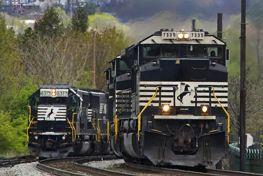 A Norfolk Southern freight train passes a train on a siding as it approaches a crossing in Homestead, Pa., Wednesday, April 27, 2022. Freight railroads and their unions are facing increasing pressure from business groups and the White House to settle their contract dispute. They face a looming strike deadline on Friday, Sept. 16, and business groups say a stoppage halting deliveries of raw materials and finished products that so many companies rely on would be an economic disaster. (AP Photo/Gen