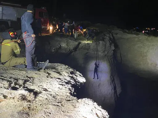 Authorities and local residents save a migrant during a large-scale rescue operation on the island of Kythira, some 225 kilometers (140 miles) south of Athens, early Thursday, Oct. 6, 2022. The operation is underway off a southern Greek island where a sailboat carrying up to 100 migrants sank in high winds. The coast guard said its vessels, private boats and a rescue helicopter were involved in the effort off the coast of the island of Kythira. (Ippolytos Prekas/kythera.news via AP)