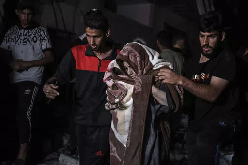 Palestinians rescue a woman survived after the Israeli bombardment on a residential building of Abu Alenan family in Rafah, southern Gaza Strip, early Saturday, May 4, 2024. (AP Photo/Ismael Abu Dayyah)