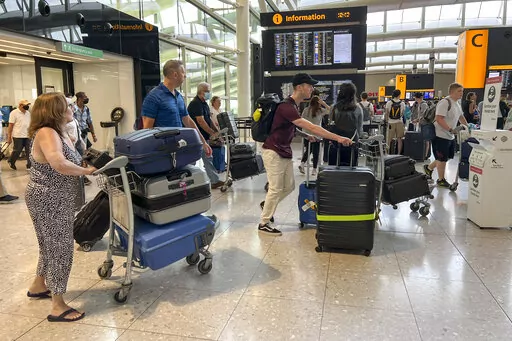 FILE- Travellers at Heathrow airport, in London, July 13, 2022. British Airways said Tuesday,Aug. 2, 2022, that it's suspending sales of short-haul flights from London's Heathrow Airport for about a week, a response to the airport's request to limit bookings to help ease travel disruptions caused by booming demand and staff shortages. (AP Photo/Alberto Pezzali, File)