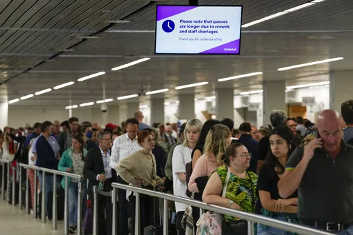 Travelers wait in long lines to check in and board flights at Amsterdam's Schiphol Airport, Netherlands, on June 21, 2022. Amsterdam’s Schiphol Airport has launched a compensation scheme for travelers who missed their flights because of lengthy delays that have plagued the busy European aviation hub for months. Schiphol announced the scheme Thursday night, Aug. 11, 2022, heading off a possible mass claim for compensation by passengers who saw their holiday plans evaporate amid hours-long delay