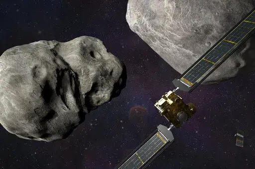 This illustration made available by Johns Hopkins APL and NASA depicts NASA's DART probe, foreground right, and Italian Space Agency's (ASI) LICIACube, bottom right, at the Didymos system before impact with the asteroid Dimorphos, left. DART is expected to zero in on the asteroid Monday, Sept. 26, 2022, intent on slamming it head-on at 14,000 mph. The impact should be just enough to nudge the asteroid into a slightly tighter orbit around its companion space rock. (Steve Gribben/Johns Hopkins APL