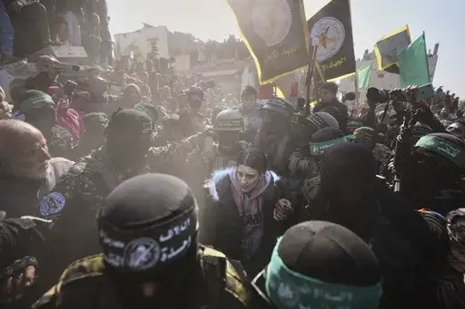 Israeli captive Arbel Yehoud, 29, who has been held hostage by Hamas in Gaza since October 7, 2023, is escorted by Hamas and Islamic Jihad fighters as she is handed over to the Red Cross in Khan Younis, southern Gaza Strip, Thursday Jan. 30, 2025.(AP Photo/Abdel Kareem Hana)