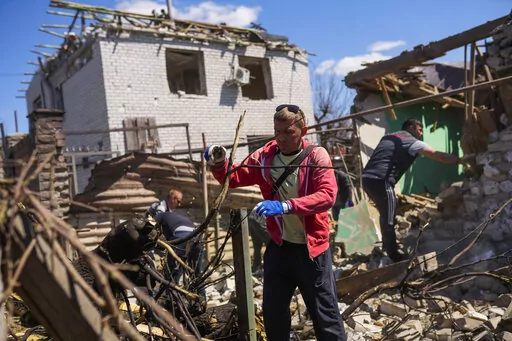 Locals remove debris from destroyed houses after a Russian rocket, hit by Ukraine's anti-aircraft system, stroke in a residencial area in Zaporizhzhia, Ukraine, Thursday, April 28, 2022. The strike came as parts of southern Ukraine prepare for a further advance by Russian forces who seek to strip the country of its seacoast. (AP Photo/Francisco Seco)
