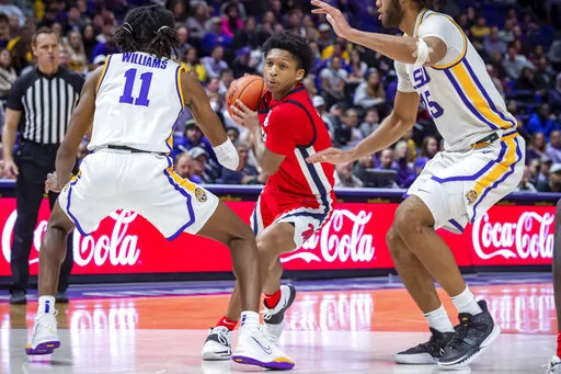 Mississippi guard Daeshun Ruffin (2) drives the ball as LSU's Justice Williams (11) and Efton Reid III defend during an NCAA college basketball game Tuesday, Feb 1, 2022, in Baton Rouge, La. (Scott Clause/The Daily Advertiser via AP)