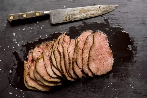 This image released by Milk Street shows a recipe for prune, peppercorn and fresh herb-rubbed roast beef. (Milk Street via AP)