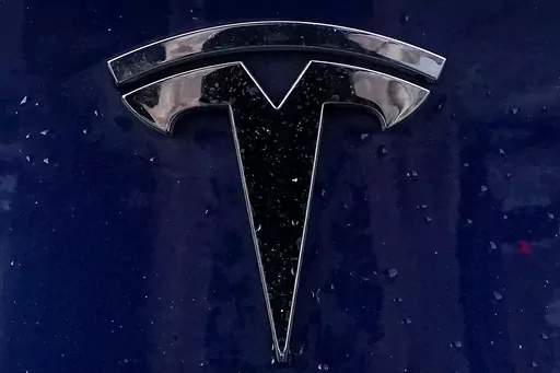 A Tesla electric vehicle emblem is affixed to a passenger vehicle Sunday, Feb. 21, 2021, in Boston. The lawyers who successfully argued that a massive pay package for Tesla CEO Elon Musk was illegal and should be voided have asked the presiding judge to award them company stock worth $5.6 billion as legal fees. The attorneys, who represented Tesla shareholders in the case decided in January, made the request of the Delaware judge in court papers filed Friday, March 1, 2024. (AP Photo/Steven Senn