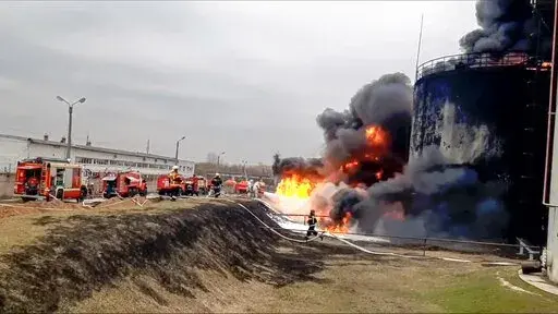 In this handout photo released by Russian Emergency Ministry Press Service on Friday, April 1, 2022, firefighters work at the site of fire at an oil depot in Belgorod region, Russia. The governor of the Russian border region of Belgorod accused Ukraine of flying helicopter gunships into Russian territory and striking an oil depot Friday morning. The depot is run by Russian energy giant Roseneft about 21 miles from the border. The governor says it was set ablaze by the attack that left two people