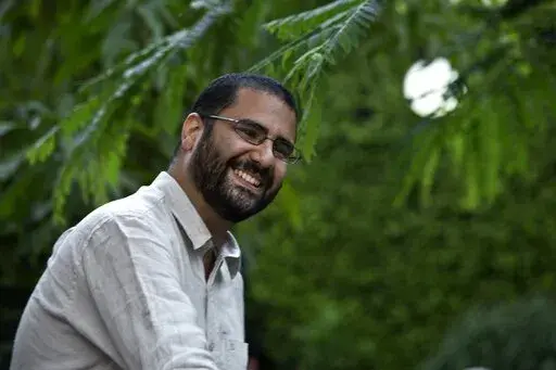 In this Monday, Sept. 22, 2014 photo, Egypt's most prominent activist Alaa Abdel-Fattah greets people prior to a conference held at the American University in Cairo, near Tahrir Square, Egypt. The family of the imprisoned Egyptian activist  says they received a letter from him on Tuesday, Nov. 15, 2022,  saying he has ended his hunger strike. The family said in a statement that Abdel-Fattah's mother, Laila Soueif, received a short note in her son’s handwriting via prison authorities. The lette