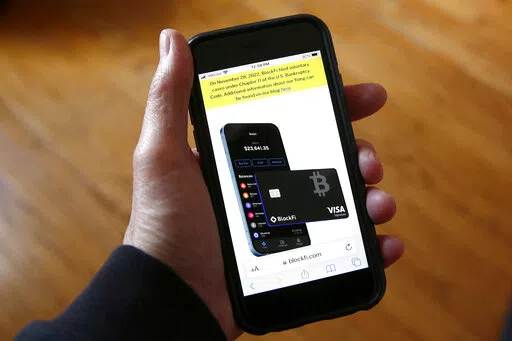 Text, in yellow, announcing cryptocurrency lender BlockFi's bankruptcy filing, appears on the company's website on a smartphone, Nov. 28, 2022, in New York. Over the past few years, a number of companies have attempted to act as the cryptocurrency equivalent of a bank, promising lucrative returns to customers who deposited their bitcoin or other digital assets. In a span of less than 12 months, nearly all of the biggest of those companies have failed spectacularly. (AP Photo/Peter Morgan, File)
