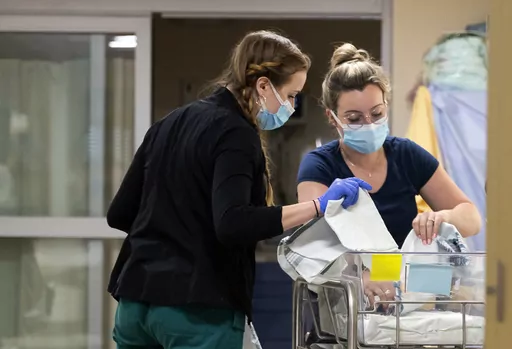 In a photo provided by the University of Vermont Health Network, licensed nursing assistant Jordan Bushy, right, and a student nurse care for newborns at the University of Vermont Children’s Hospital in Burlington, Vt., Friday, April 28, 2023. Research led by Dr. Leslie Young of the children’s hospital has found that babies born to opioid users had shorter hospital stays and needed less medication when their care emphasized parent involvement, skin-to-skin contact and a quiet environment. (R