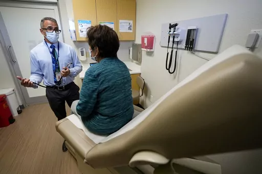Nurse practitioner Anthony Carano speaks with a patient at the Mountain Park Health Center, Thursday, March 30, 2023, in Phoenix. As heat waves fueled by climate change arrive earlier, grow more intense and last longer, people over 60 who are more vulnerable to high temperatures are increasingly at risk of dying from heat-related causes. Heat related deaths are challenging community health systems, utility companies, apartment managers and local governments to better protect older people when te