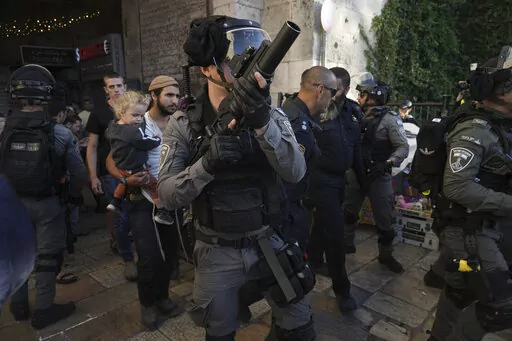 Israeli security forces escort a group of Jews outside Damascus Gate, in Jerusalem's Old City, Wednesday, April 20, 2022. Police prevented hundreds of ultra-nationalist Israelis from marching around predominantly Palestinian areas of Jerusalem's Old City. The event planned for Wednesday was similar to one that served as one of the triggers of last year's Israel-Gaza war. (AP Photo/Mahmoud Illean)