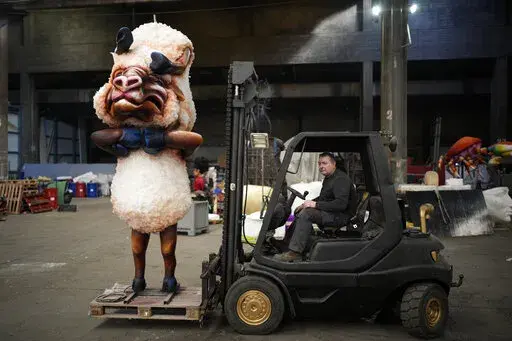 Artisan Pierre Povigna moves a carnival figure at a warehouse in Nice, southern France, Thursday, Feb. 10, 2022. The theme of the Carnival's 149th edition in the French Riviera city of Nice is King of Animals. A loud celebration of nature, human connection and life itself after months of lockdowns, silence, social distancing and banned public gatherings, kicks off on Friday. (AP Photo/Daniel Cole)