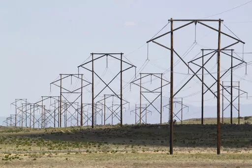 This May 20, 2012 file photo shows one of the major transmission lines that runs to the west of Albuquerque, N.MThe federal government has finished another environmental review of a proposed transmission line that will carry wind-generated electricity from rural New Mexico to big cities in the West and similar reviews are planned for two more projects that would span parts of Utah and Nevada, the U.S. Interior Department announced Thursday, April 28, 2022. (AP Photo/Susan Montoya Bryan, File)